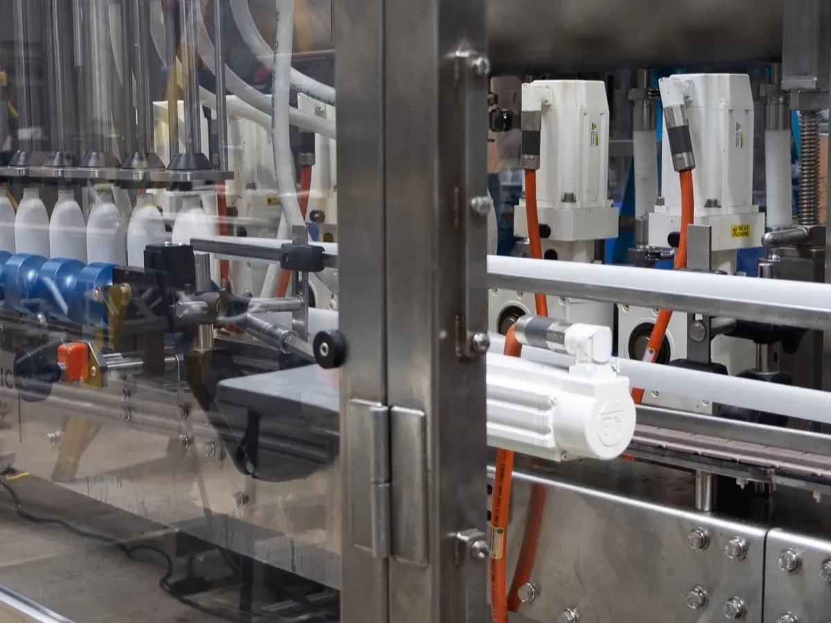 Multihead filler dispensing product into bottles on the fill line