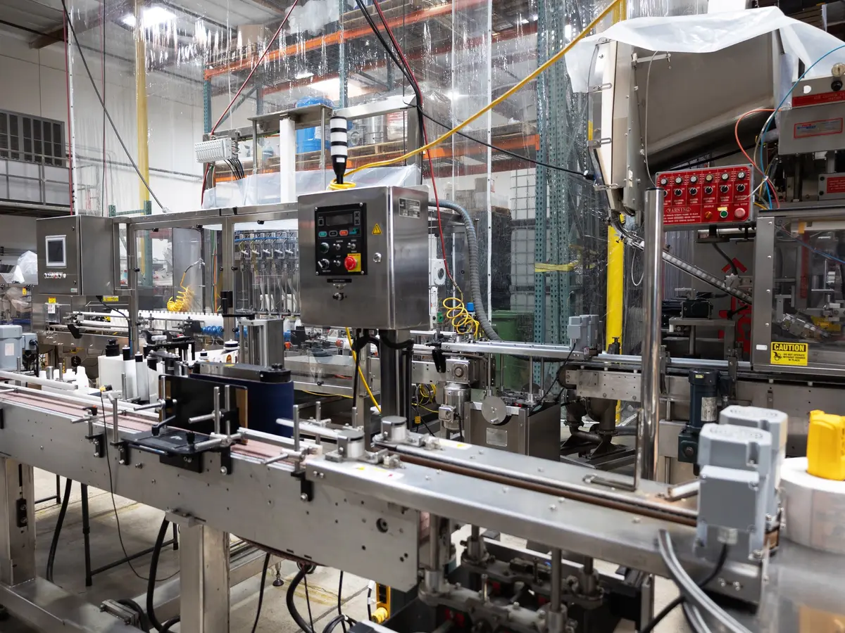 Bottles moving through an automated labeling line, ready for the induction sealer