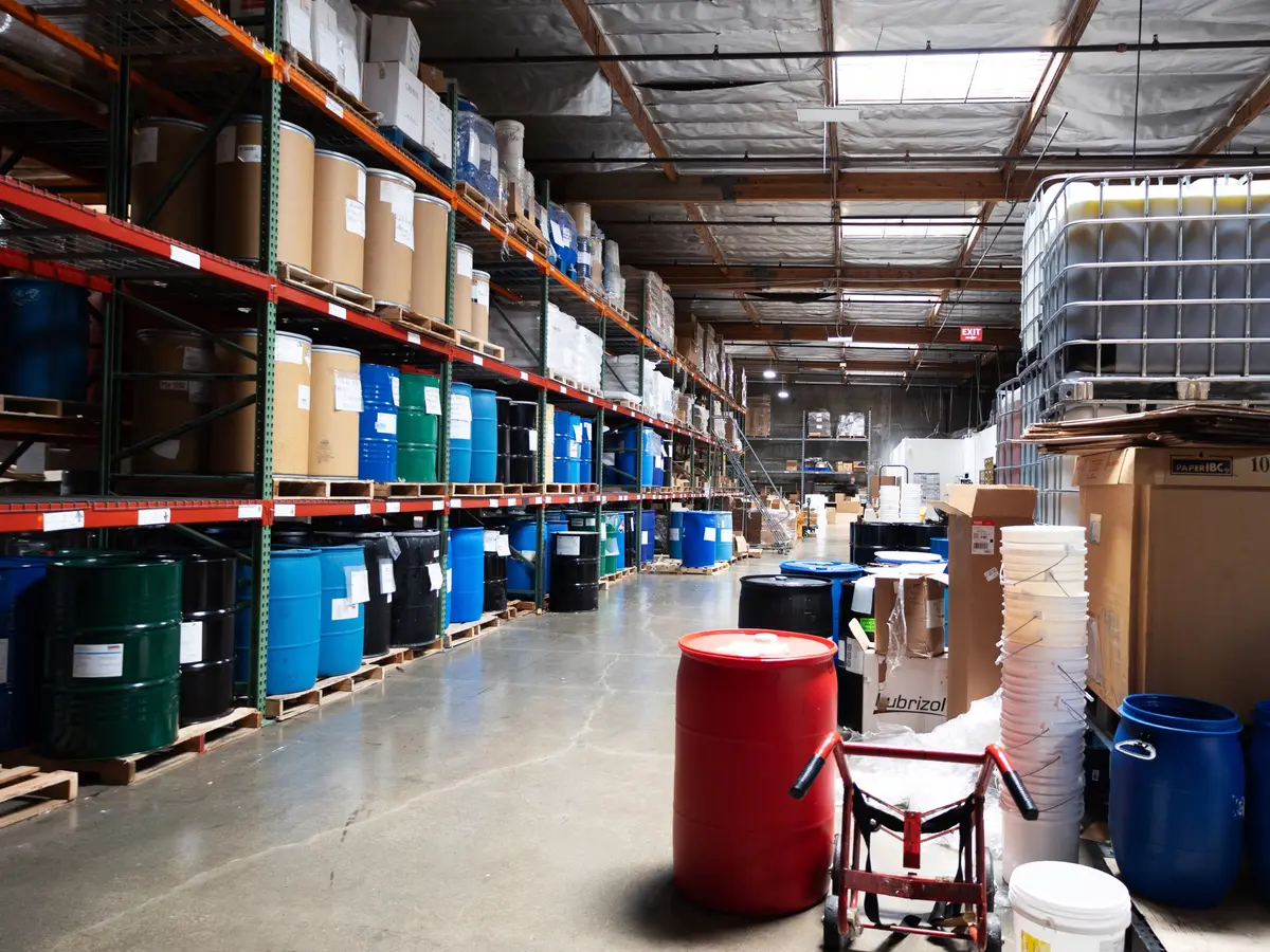 Pallet racking stocked with raw material drums and cartons in the warehouse
